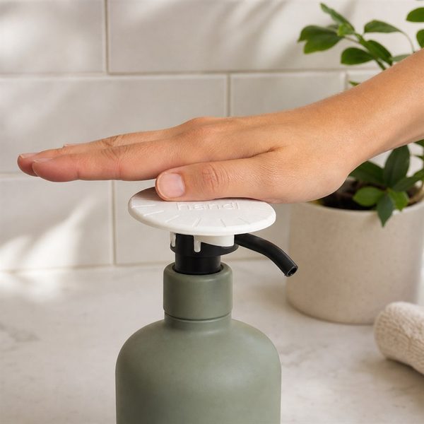 A whole hand pressing the PALM fitted to a soap pump